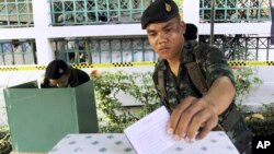 FILE - A Thai soldier casts his vote during the general election at a polling station in Bangkok, Thailand, Feb. 2, 2014. Thailand has taken another step toward holding elections in 2019 by easing some restrictions on political activities to allow parties to conduct basic functions, but they are still barred from campaigning.