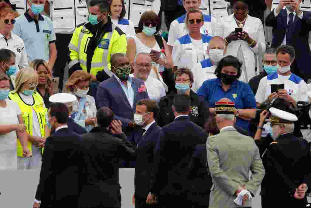 امانوئل مکرون رئیس جمهوری فرانسه در حاشیه مراسم روز باستیل یا همان جشن‌های روز ملی فرانسه در پاریس با گروهی از کارکنان بخش درمان خوش و بش می‌کند. امسال جشن‌های این روز نمادین در فرانسه تحت تاثیر فراگیری کرونا قرار گرفته است. 