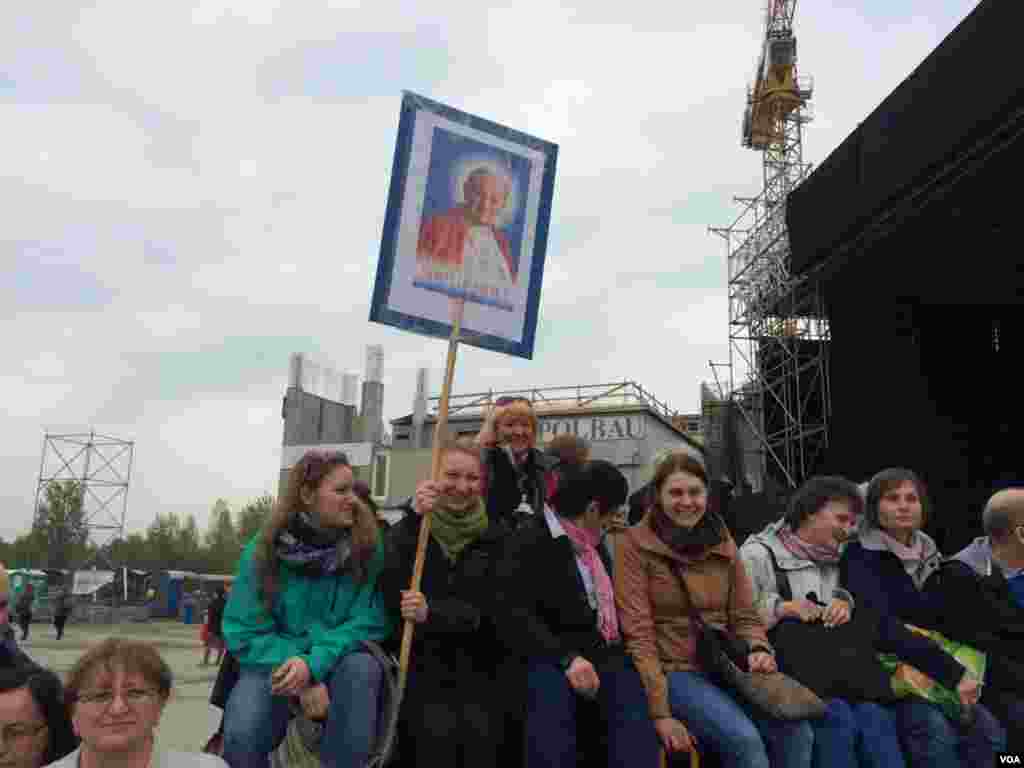 Sekelompok orang menunggu upacara yang disiarkan lewat televisi dari Vatikan di Crakow, Ukraina, 27 April 2014. (Jerome Socolovsky/VOA)