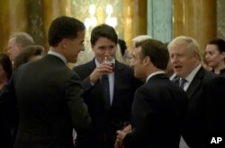 In this grab taken from video on Dec. 3, 2019, Britain's Prime Minister Boris Johnson, right, speaks during a NATO reception.