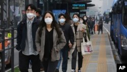 People wearing masks to protect from air pollution walk at a bus station in Seoul, South Korea, Wednesday, March 6, 2019. (AP Photo/Ahn Young-joon)