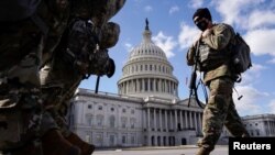 Soldados de la Guardia Nacional caminan frente al Capitolio de EE. UU. en Washington, DC, el 6 de marzo de 2021. 