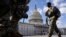 Soldados de la Guardia Nacional caminan frente al Capitolio de EE. UU. en Washington, DC, el 6 de marzo de 2021. 