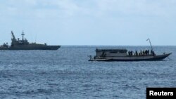 Kapal Angkatan Laut Australia (kiri) mengawasi sebuah kapal pencari suaka di dekat Pulau Christmas, Australia (foto: dok).