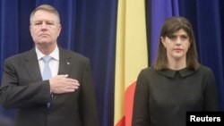 FILE - Romanian President Klaus Iohannis and the Chief of anti-corruption prosecuting agency DNA, Laura Codruta Kovesi, stand while listening to the national anthem being played at the beginning of the anti-corruption agency's annual report, in Bucharest, Romania, Feb. 28, 2018. 