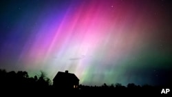 Auroras boreales iluminan el cielo sobre una granja en Brunswick, Maine, el 10 de mayo de 2024. 