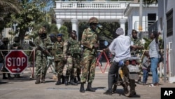 Des soldats sénégalais fouillent un motocycliste à l'entrée du complexe de l'Etat à Banjul, Gambie, 24 janvier 2017. 