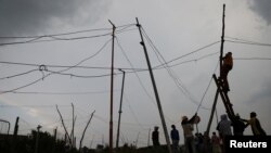 FILE - Locals illegally connect electricity, in Soweto, South Africa January 18, 2022. 