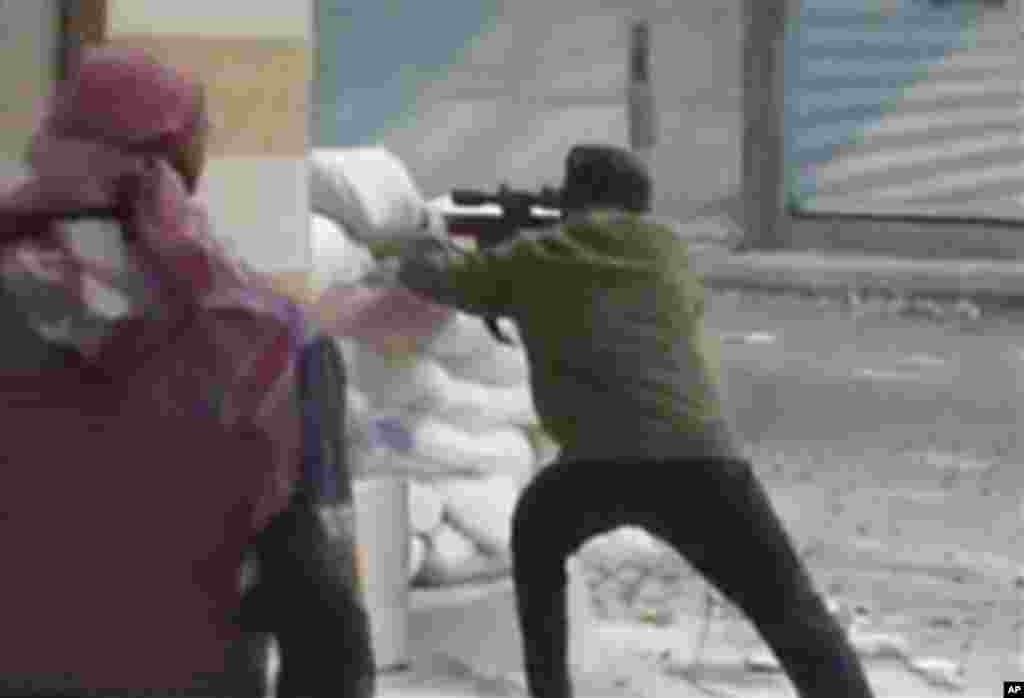 This image from amateur video AP obtained from Ugarit News has been authenticated based on its contents and other AP reporting and shows a rebel firing a weapon around a corner at Syrian government forces in Damascus, Syria Friday Dec. 7, 2012. Fighting around the Syrian capital has intensified in recent days as rebels press a battle they hope will lead to the collapse of President Bashar Assad&#39;s regime after 20 months of conflict. (AP Photo/Ugarit News via AP Video)