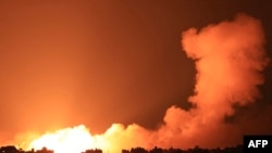 Explosions illuminate the sky during Israeli strikes on Gaza City on October 10, 2023.