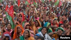 Farmers wave flags and shout slogans during a protest rally demanding loan waivers and the transfer of forest lands to villagers who have farmed there for decades, in Mumbai, India, Nov. 22, 2018. 