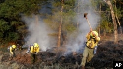 Bomberos tratan de abrir barreras contra el fuego en una colina en la zona de Oakmont, en Santa Rosa, California. Oct. 12, 2017.