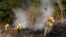 Bomberos tratan de abrir barreras contra el fuego en una colina en la zona de Oakmont, en Santa Rosa, California. Oct. 12, 2017.