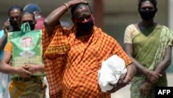 Sejumlah transgender berjalan sambil menjaga jarak aman ketika menerima bantuan makanan gratis di tengah pemberlakuan karantina wilayah untuk mencegah penyebaran Covid-19 di Chennai, India, 1 Mei 2020. (Foto: AFP)