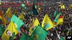 Ribuan pendukung pemberontak PKK melambai-lambaikan bendera-bendera PKK dan poster-poster pemimpinnya Abdullah Ocalan, di kota Diyarbakir, Turki tenggara, sambil Ocalan menerukan gencatan senjata dan penarikan pasukannya dari Turki (foto, 21/3/2013).