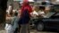 A woman and two children stand along the Jos-Maiduguri road as they wait to board a vehicle, after the military declared a 24-hour curfew over large parts of Maiduguri in Borno State, Nigeria, May 19, 2013.