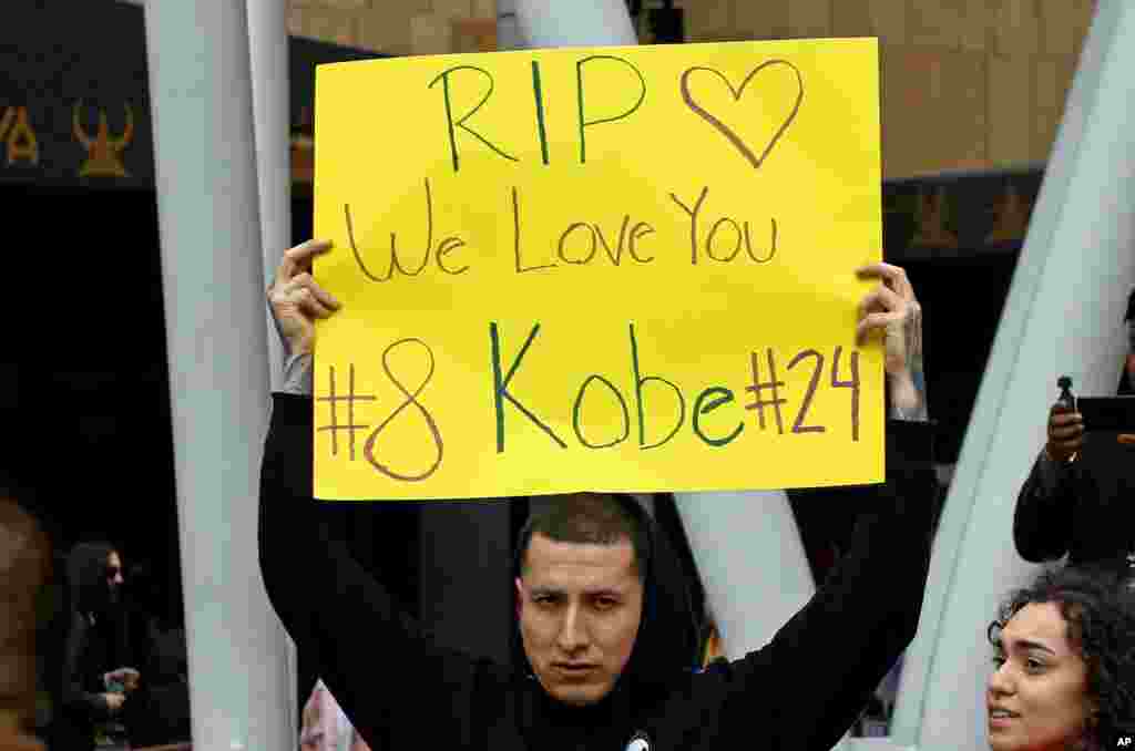 A man holds a sign memorializing Kobe Bryant at the LALive area across from Staples Center, home of the Los Angeles Lakers, after word of the Lakers star&#39;s death in a helicopter crash in downtown Los Angeles, Jan. 26, 2020. 