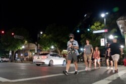 People make their way along The Strip, the University of Alabama's bar scene, Aug. 15, 2020, in Tuscaloosa, Ala. More than 20,000 students returned to campus for the first time since spring break.