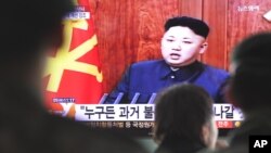 한국 서울역에서 1일 행인들이 김정은 북한 국방위 제1위원장의 신년사 관련 뉴스를 보고 있다.