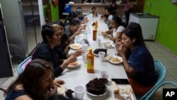 Migrantes, en su mayoría ciudadanos mexicanos recientemente deportados de Estados Unidos, cenan en el refugio para migrantes San Juan Bosco en Nogales, México, el martes 25 de junio de 2024. 