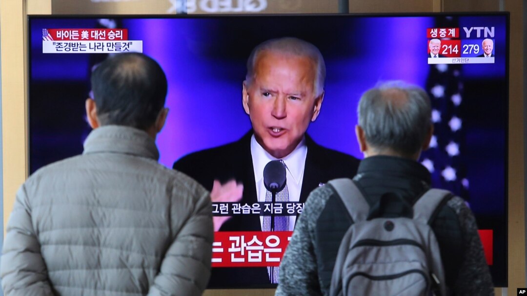 Personas observan en una pantalla al presidente electo de EE. UU., Joe Biden, en la estación de trenes de Seúl, el domingo 8 de noviembre de 2020.