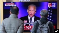 Personas observan en una pantalla al presidente electo de EE. UU., Joe Biden, en la estación de trenes de Seúl, el domingo 8 de noviembre de 2020.