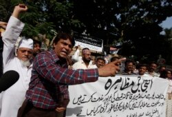 FILE - Pakistani journalists chant slogans during a protest against the attack on political talk show host Hamid Mir, outside the press club in Karachi, April 20, 2014.