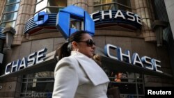 A woman passes by a JPMorgan Chase bank in Times Square in New York City, March 7, 2019.