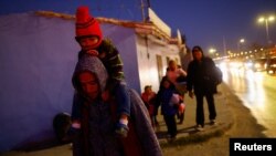 Sebuah keluarga migran tampak berjalan menuju jembatan perbatasan internasional Paso del Norte di Ciudad Juarez, Meksiko, pada 3 Februari 2023. (Foto: Reuters/Jose Luis Gonzalez)