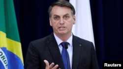 FILE - Brazil's President Jair Bolsonaro speaks during a signing ceremony of a presidential decree providing federal organizations with free of charge publications by National Press, in Brasilia, Brazil, Sept. 30, 2019. 