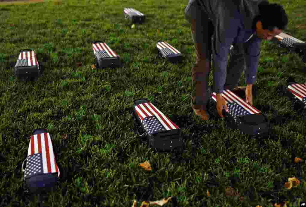 Charles Mason III collects musical instrument cases representing coffins of victims of police violence outside of Baltimore City Hall in Baltimore, Maryland, USA, Dec. 16, 2015.&nbsp;Mason&#39;s mentor, artist Paul Rucker, placed the cases in response to the trial for officer William Porter, one of six Baltimore city police officers charged in connection to the death of Freddie Gray. The trial ended with a hung jury and mistrial.&nbsp;