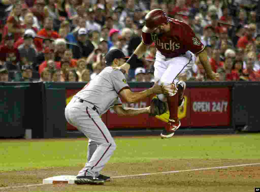 VÐV Anthony Rendon (trái) thuộc đội Washington Nationals cản phá VÐV Adam Eaton của đội Arizona Diamondbacks trong một trận đấu bóng chày ở thành phố Phoenix, bang Arizona, ngày 29 tháng 9, 2013.