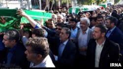 Mourners carry the bodies of three girls who died in a school fire in Iran's southeastern city of Zahedan as part of a funeral procession, Dec. 19, 2018. 