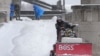 Workers clear snow from a walkway in St. Louis, Missouri, Jan. 5, 2025.