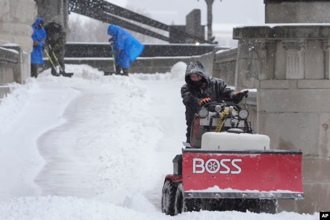 Los trabajadores limpian la nieve de una pasarela el domingo 5 de enero de 2025 en St. Louis. (Foto AP/Jeff Roberson)