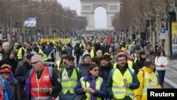 Protesters walk down the Champs-Elysees during a demonstration by the "yellow vest" movement in Paris, March 9, 2019.