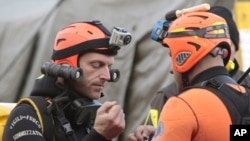 Italian divers chat as they prepare to head out to the cruise ship Costa Concordia, as it lays on its side after running aground off the tiny Tuscan island of Giglio, Italy, January 19, 2012.