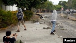 Manifestantes usan hondillas para repeler una embestida de la guardia nacional en San Cristóbal, Venezuela, a unos 660 kilómetros de Caracas.