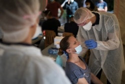 FILE - A woman is tested for COVID-19 at a mobile testing center in Marseille, France, Sept. 24, 2020.