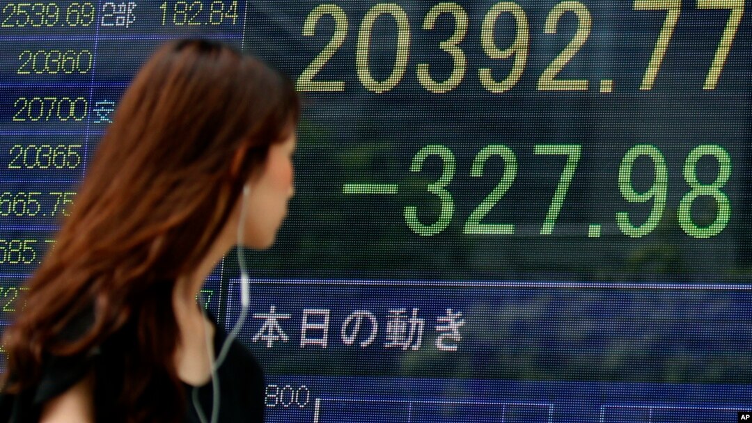 Bảng điện tử hiện thị chỉ số Nikkei của Tokyo sụt giảm 327,98 điểm xuống còn 20.392,77 điểm hôm 12/8/2015. 