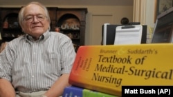 74-year-old college student Charles Buckley sits in front of his text books at his home. Buckley recieved his Bachelor of Science in nursing from the University of Southern Mississippi in 2010.