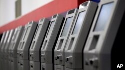FILE - ATMs, automated teller machines, are lined up during the manufacturing process at Diebold Nixdorf in Greensboro, North Carolina, Aug. 30, 2017. 