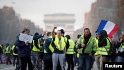 Fransa hökumətin yanacaq vergisinin artırılması Yellow Vests (Gilets jaunes) march behind a banner reading "Yellow vests are angry" as they protest high fuel prices in Rochefort, southwestern France, Nov. 24, 2018,