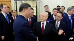 资料照片：2023年12月12日，中国国家主席习近平（左）和越南总书记阮富仲在越南河内握手。（美联社照片）
