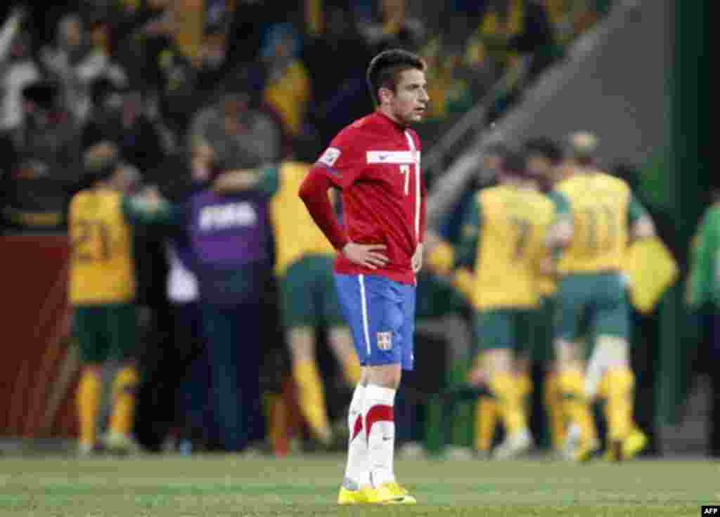 Serbia's Zoran Tosic, front, reacts as Australian players celebrate after scoring during the World Cup group D soccer match between Australia and Serbia at Mbombela Stadium in Nelspruit, South Africa, Wednesday, June 23, 2010. (AP Photo/Darko Vojinovic)