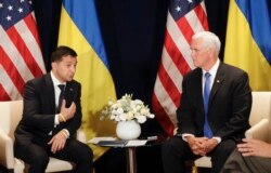 FILE - Ukraine's President Volodymyr Zelenskiy, left, gestures next to U.S. Vice President Mike Pence, during a bilateral meeting in Warsaw, Poland, Sunday, Sept. 1, 2019.