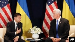 Ukraine's President Volodymyr Zelenskiy, left, gestures next to U.S. Vice President Mike Pence, during a bilateral meeting in Warsaw, Poland, Sunday, Sept. 1, 2019. 