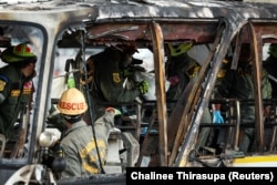 Petugas tanggap darurat berada di bus terbakar yang membawa guru dan siswa dari sekolah Wat Khao Phraya, di pinggiran Bangkok, Thailand, 1 Oktober 2024. (Foto: Chalinee Thirasupa/REUTERS)