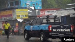 Autos de la policía de Nicaragua patrullan un mercado en Managua el 21 de junio de 2021.