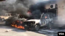 Cars burn after angry police protesters set fire to them at the Ministry of Finance. (VOA Creole/Matiado Vilme)